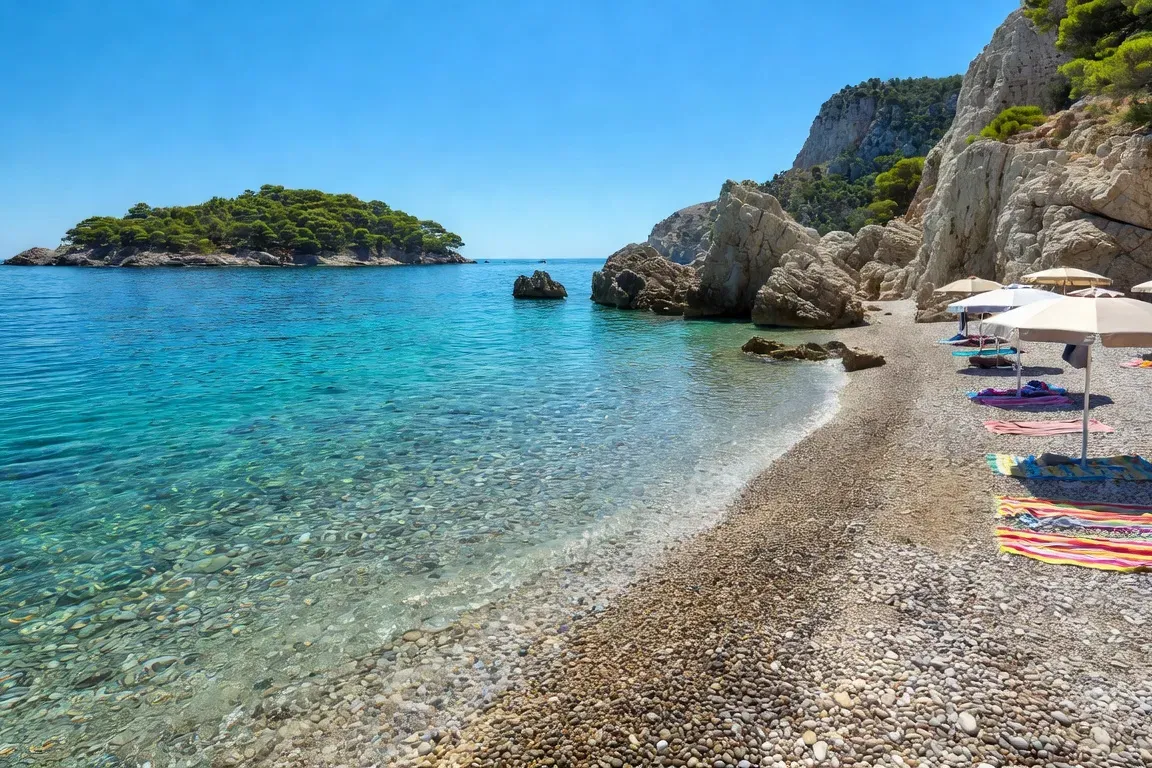Plage de galets dalmate avec eaux turquoise vers une ile en arriere-plan